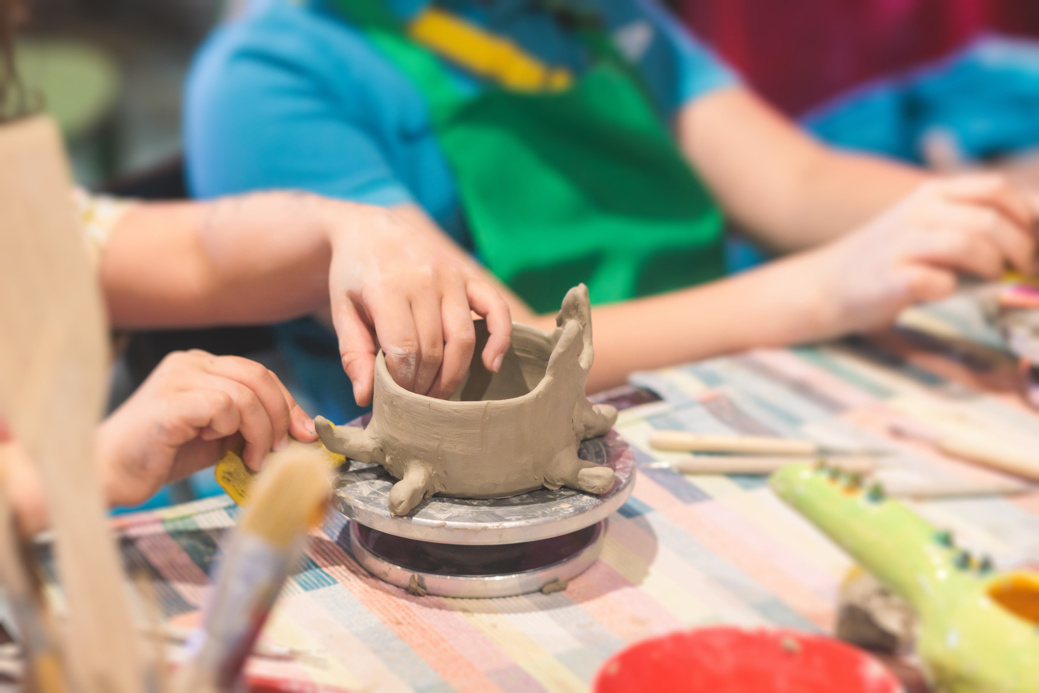 Pottery lesson master class for kids children, process of making clay pot on pottery wheel, potter wet hands creating ceramic crockery handcrafts, ceramist molding jar or vase