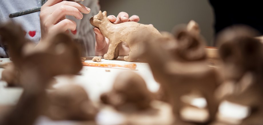 girl sculpts from clay kitten